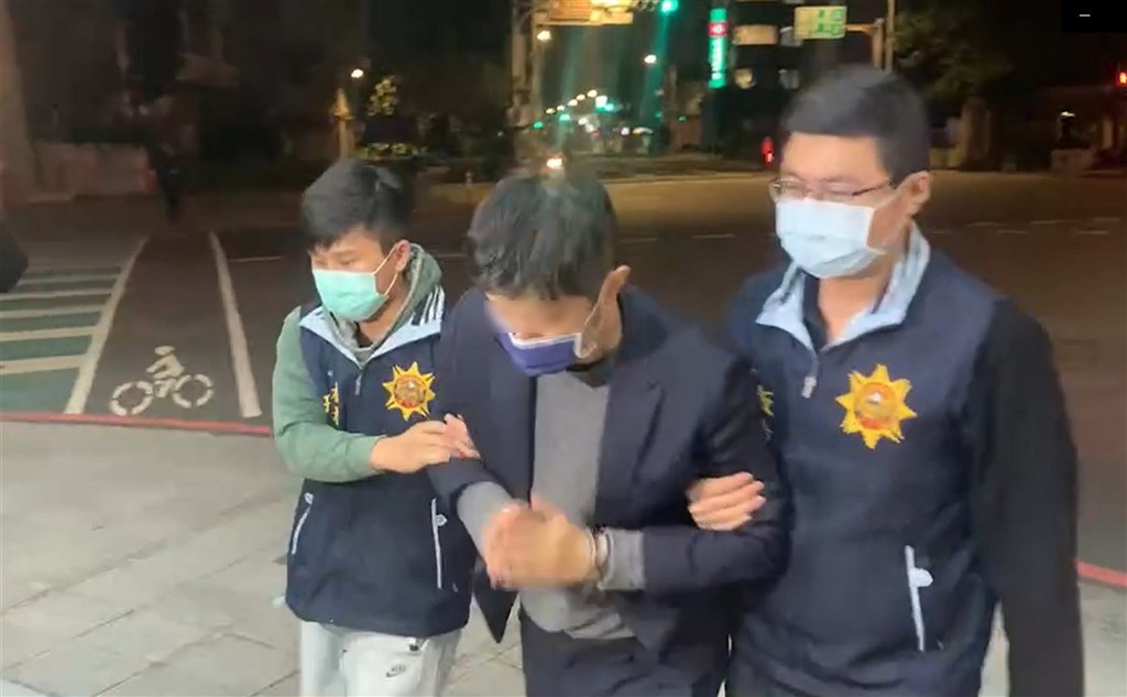 Lin (center) being escorted by police. 
