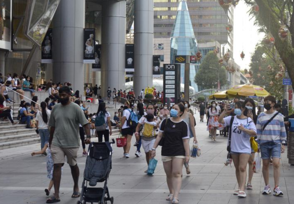 People wearing protective face masks walk along the Orchard Road shopping area in Singapore on Nov. 28, 2021. When Singapore embarked upon its strateg...
