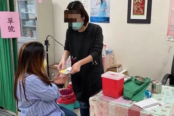 Migrant worker receiving vaccine card. (Hsinchu County Police Bureau photo)
