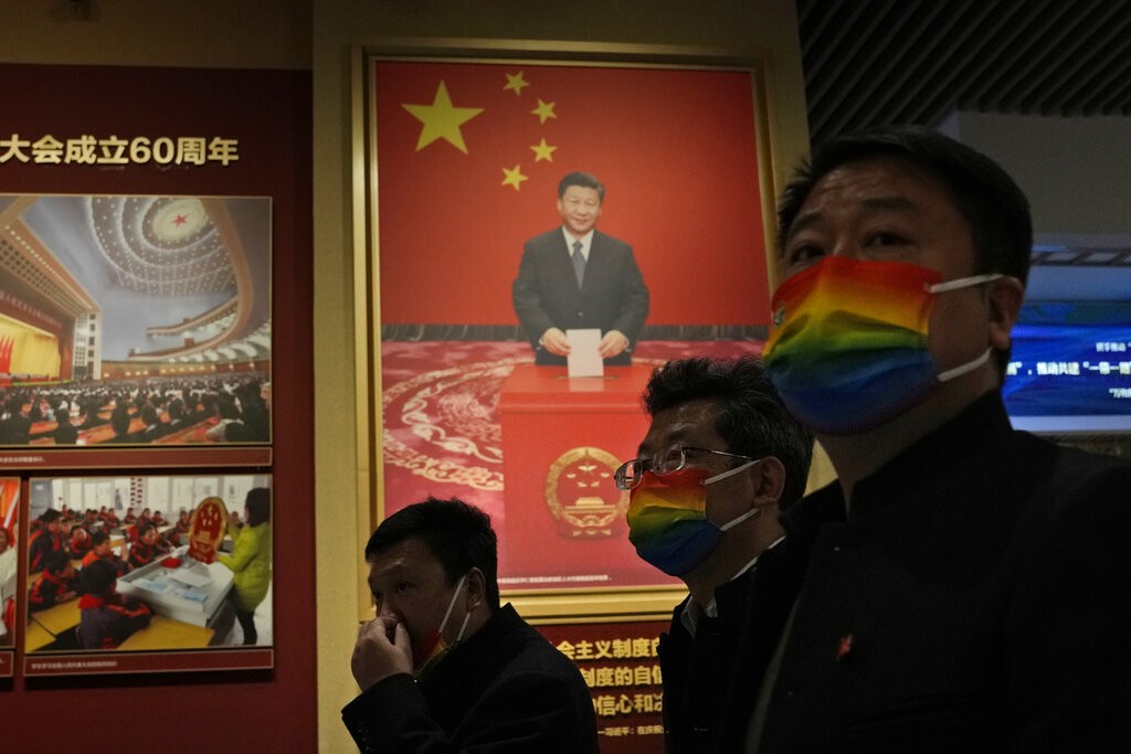 A visitor passes by a photo of the Chinese President Xi Jinping in Beijing, China, Nov. 12, 2021.
