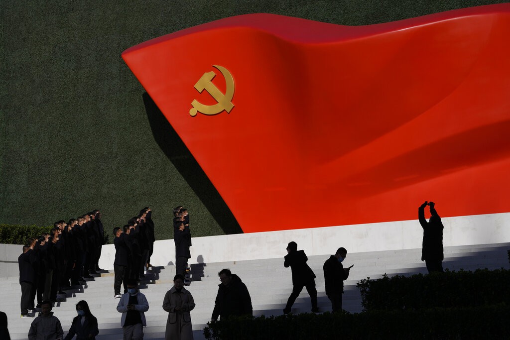 Chinese Communist Party members pose for photos with a sculpture of the party flag outside the Museum of the Communist Party of China in Beijing,...