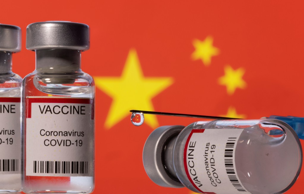 Vaccine vials and syringe in front of Chinese flag. (Reuters image)
