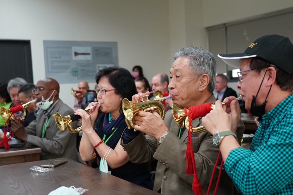 Diplomats playing music at a brass music instrument factory. (CNA, Chiayi County Government photo)
