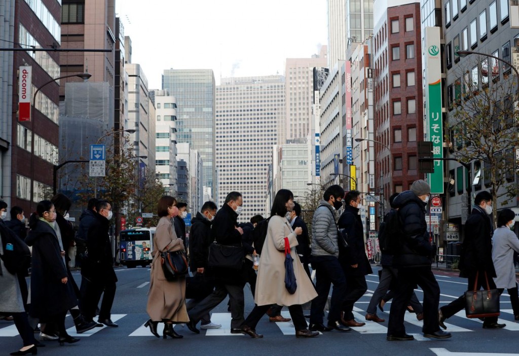 Pedestrians wearing protective masks, following the coronavirus disease (COVID-19) outbreak, make their way during commuting hour at a business distri...