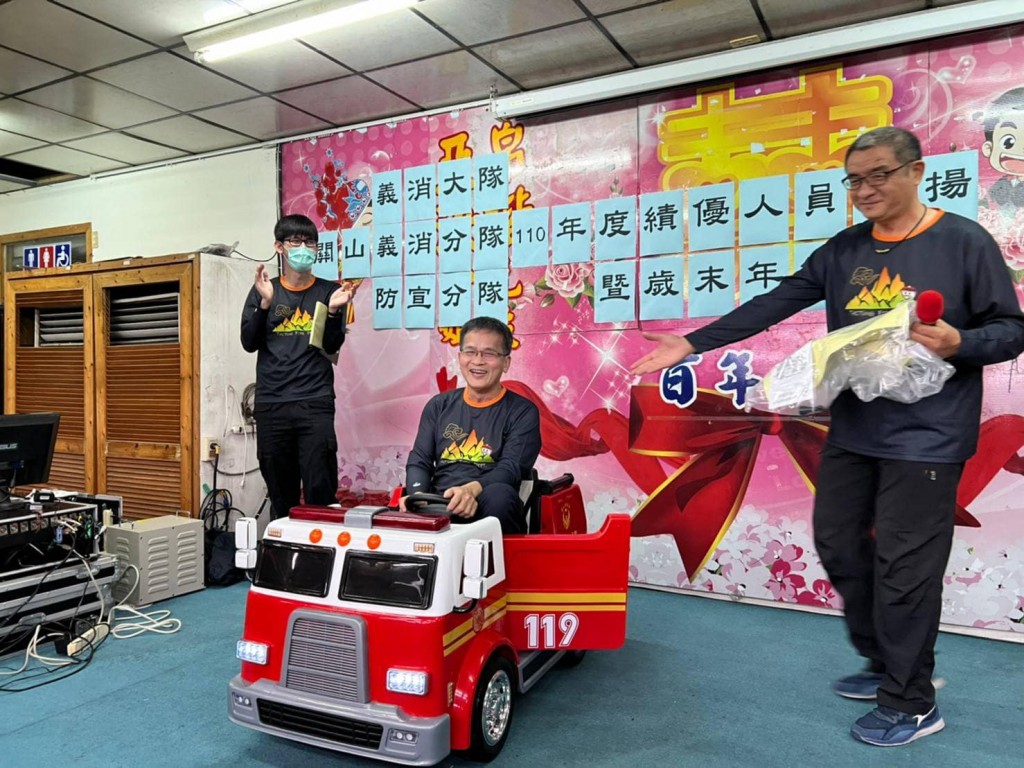 Volunteer firefighter Ho Ming-chang poses for a photo sitting in his retirement gift, an electric fire engine. (Facebook, Guanshan Volunteer Firefight...