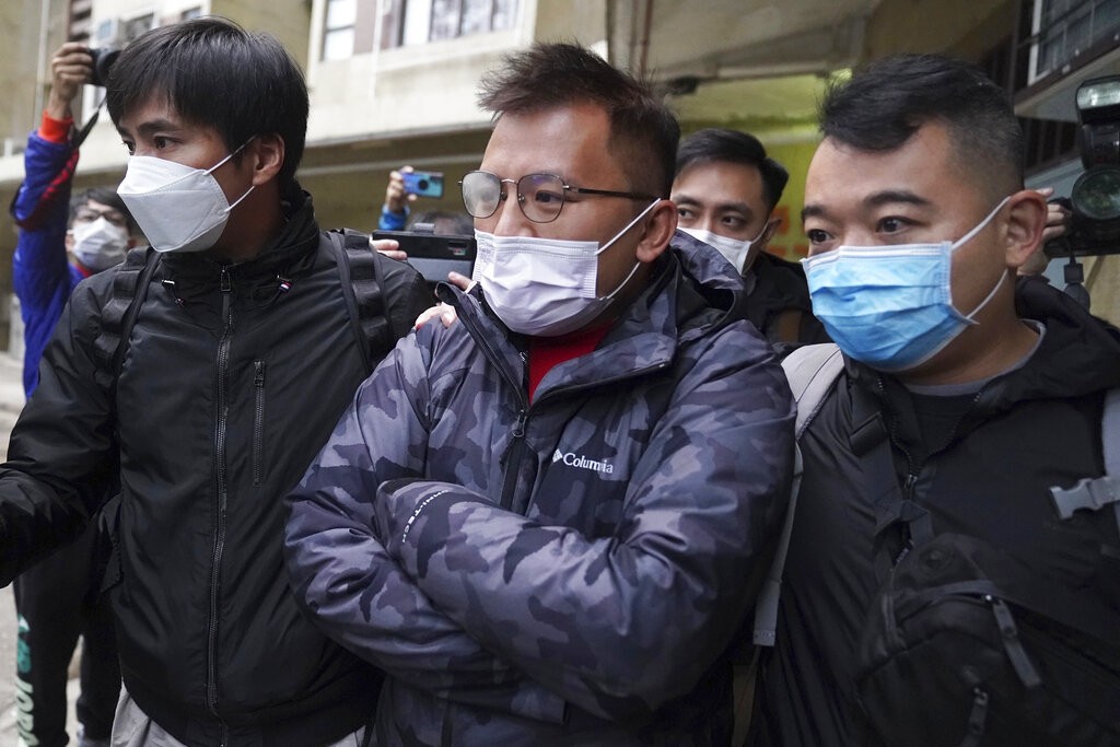 Senior editor of "Stand News" Ronson Chan, center, is arrested by police officers in Hong Kong, Wednesday, Dec. 29, 2021. 
