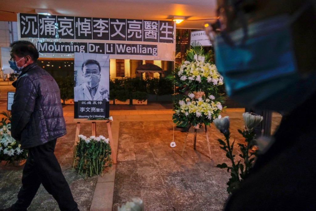 People wearing masks attend a vigil for late Li Wenliang, an ophthalmologist who died of coronavirus at a hospital in Wuhan, in Hong Kong, China Febru...