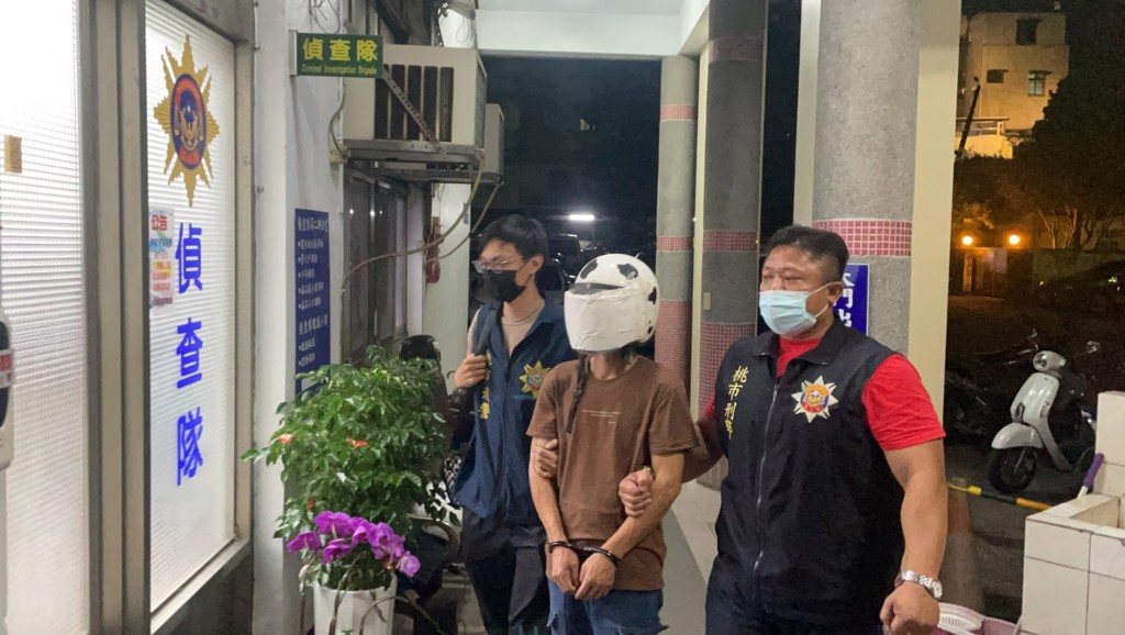 Wang (center) being escorted by police. (Taoyuan City Police Bureau photo)
