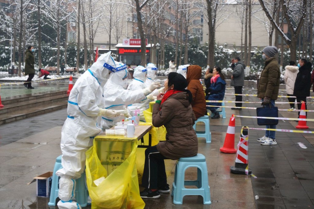 Medical workers in protective suits collect swabs from residents during a citywide nucleic acid testing following cases of the coronavirus disease (CO...