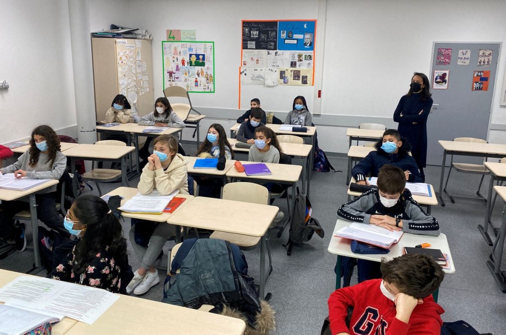 Schoolchildren, wearing protective face masks, work in a classroom at the College Jean Renoir Middle School in Boulogne-Billancourt, near Paris, Franc...