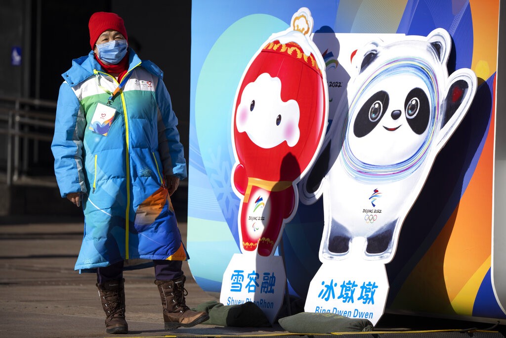 圖為1月15日的北京街頭, 一名婦人和2022年第24屆冬季奧運會吉祥物冰墩墩, 以及第13屆冬季帕運會吉祥物雪容融合影 (美聯社)
