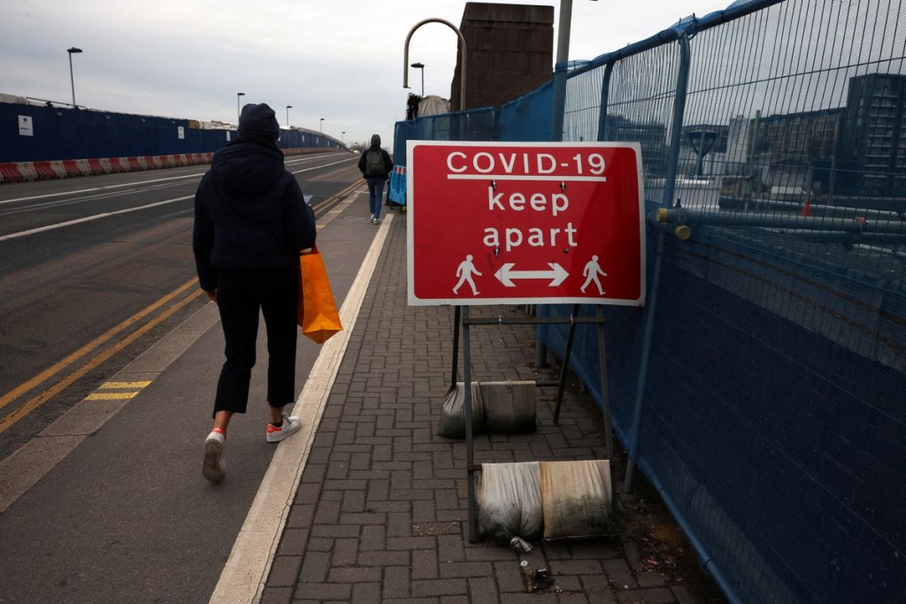 People socially distance as they walk across Wandsworth Bridge amid the coronavirus disease (COVID-19) outbreak in London, Britain, January 10, 2022. ...