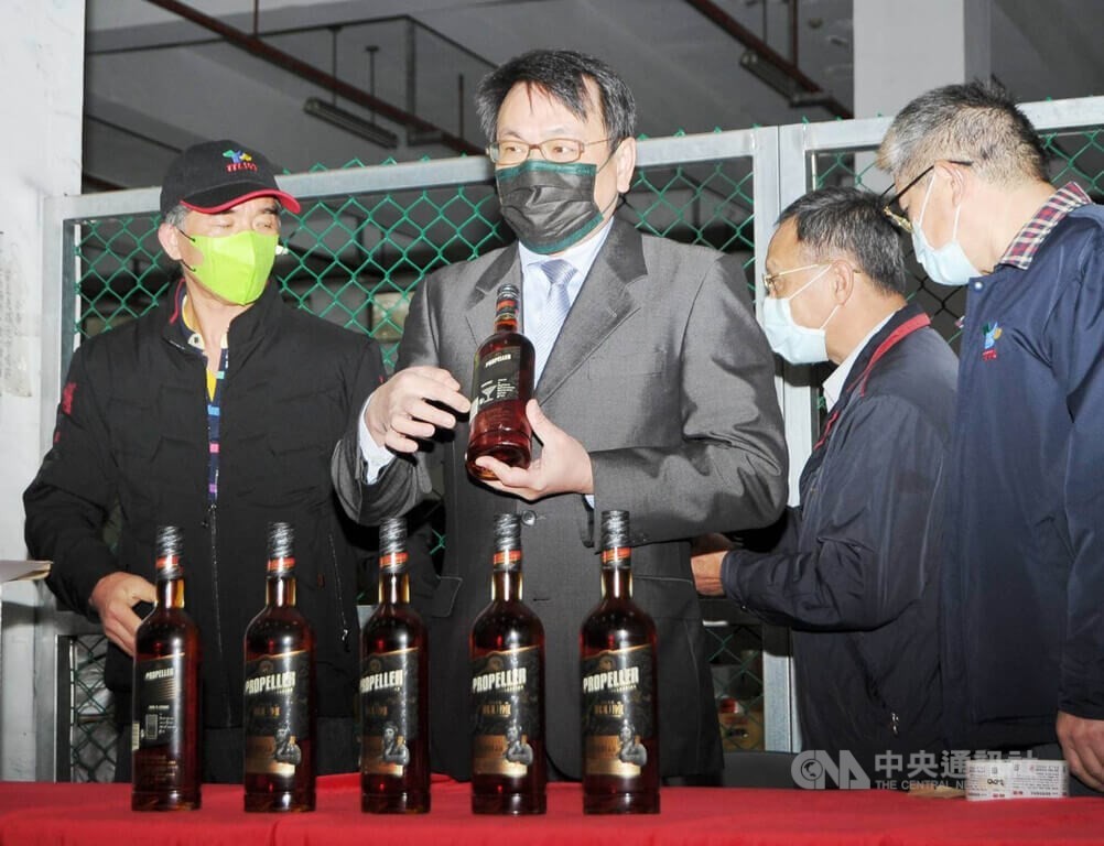 Taiwan Tobacco and Liquor Corporation Chair Ting Yen-che holding a bottle of Lithuanian dark rum.
