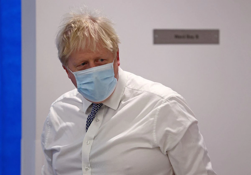 Britain's Prime Minister Boris Johnson wearing a face covering to help mitigate the spread of Covid-19, reacts during his visit to Milton Keynes U...