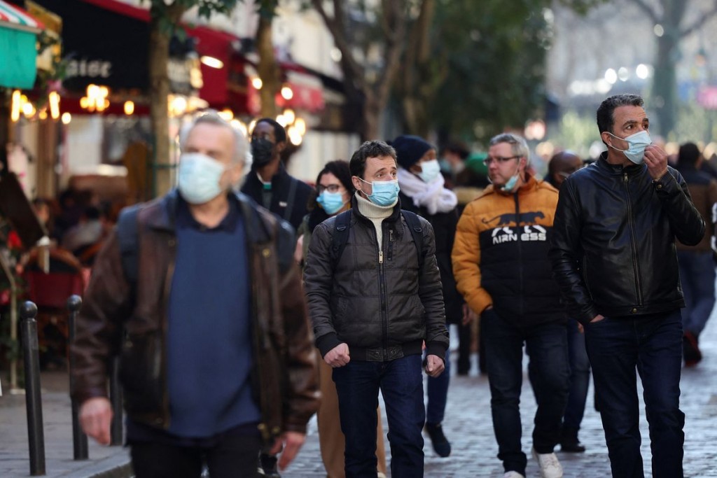 People wearing protective face masks walk in a street in Paris, France, February 9, 2022. REUTERS/Sarah Meyssonnier
