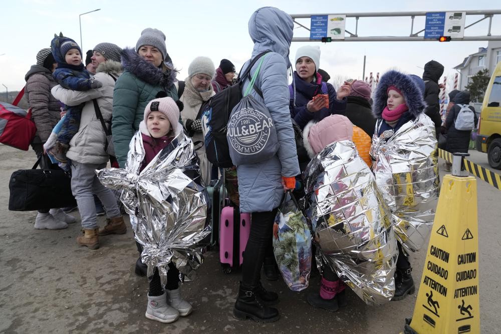 Refugees from Ukraine standing at the border with Moldova Thursday. 
