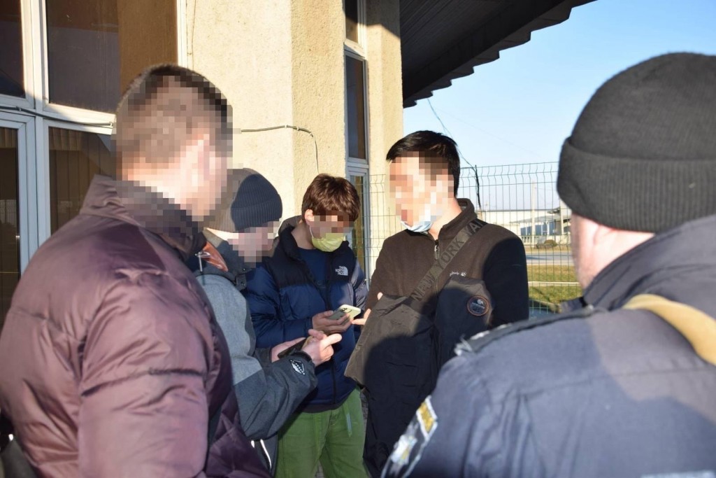 Suspect (second from right) being questioned by authorities. (State Border Guard Service of Ukraine photo)
