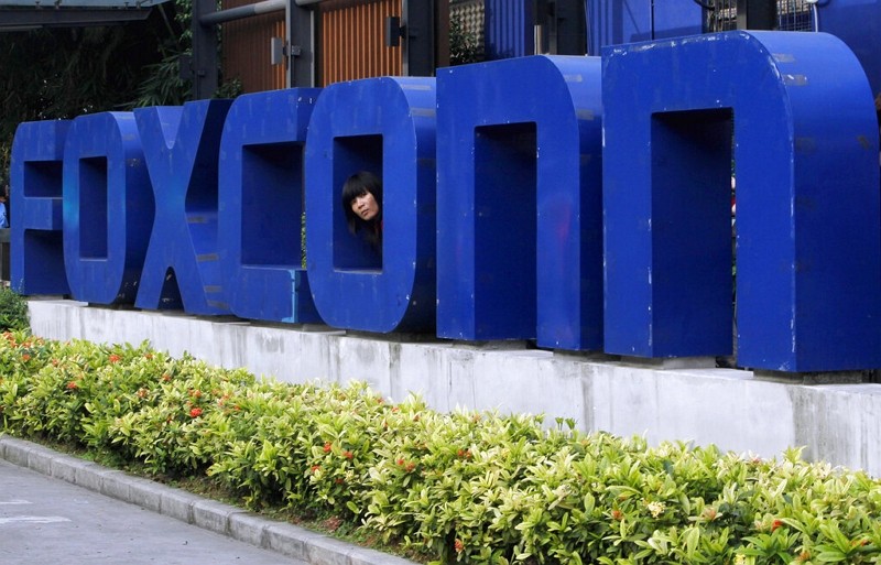 A head pops out through a Foxconn logo in Shenzhen. 
