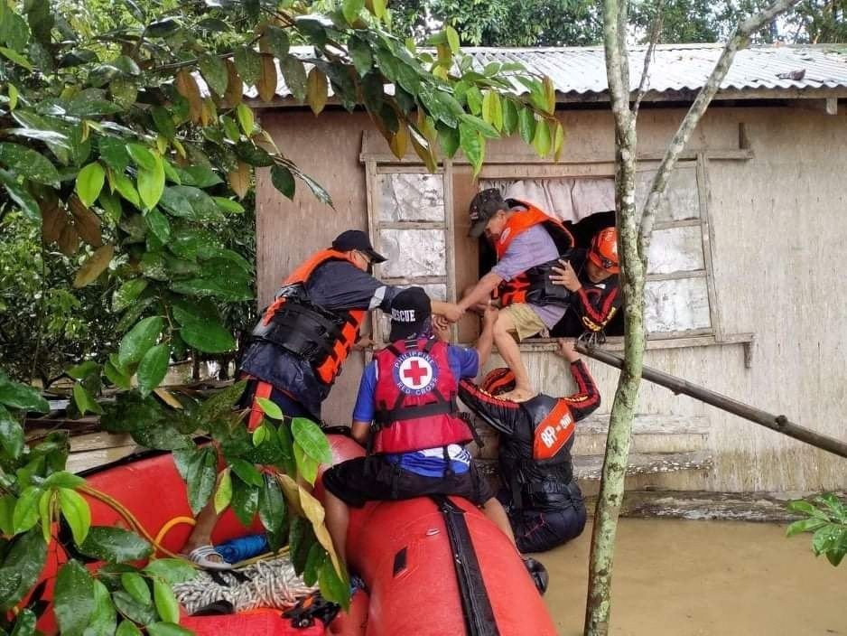 Rescue personnel assist a man onto a rescue boat, after the tropical storm Megi hit, in Capiz Province, Philippines April 12, 2022. Philippine Coast G...