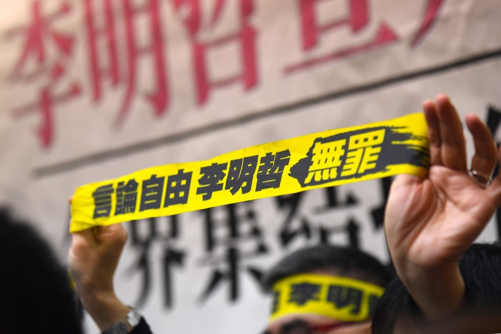 File photo of a protestor holding up a banner reading, "Freedom of speech, Lee Ming-che is innocent." 
