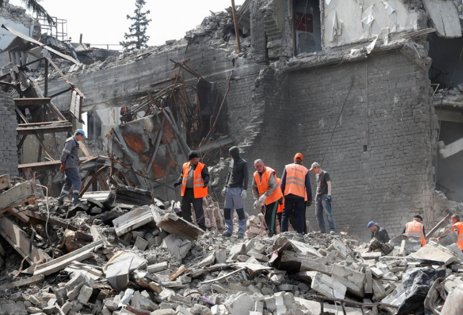 Emergency management specialists and volunteers remove the debris of a theatre building destroyed in the course of Ukraine-Russia conflict in the sout...