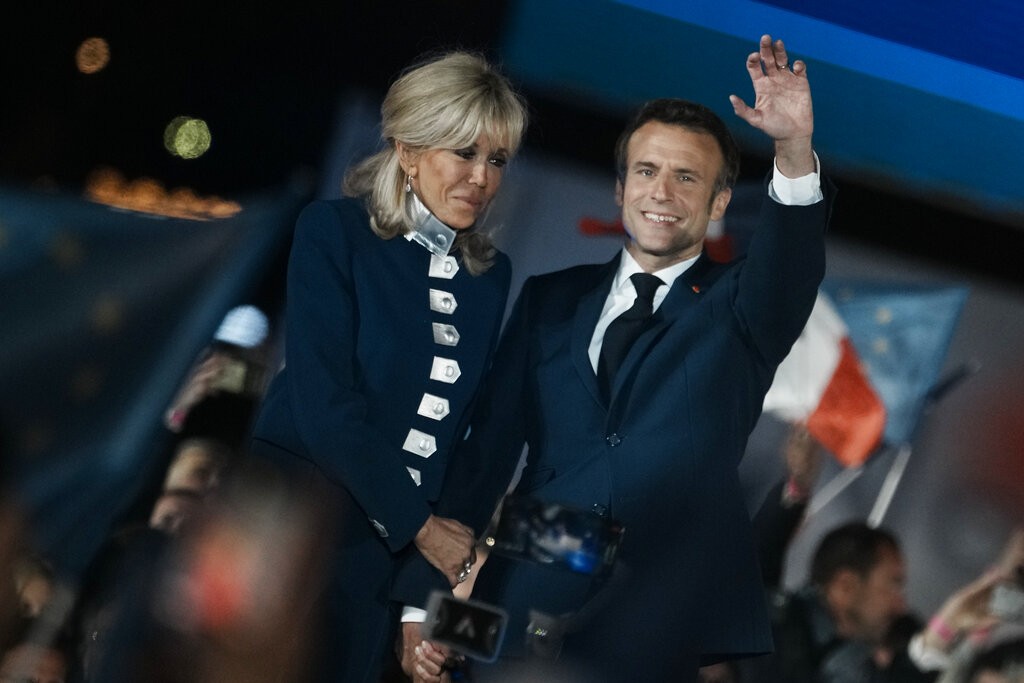 圖為巴黎時間4/24晚間馬克宏順利連任總統後,  與妻子一起站在台上接受歡呼 (美聯社) 
