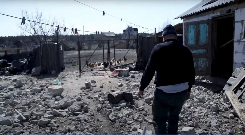A resident walks among debris, amid Russia's invasion, in Moshchun village, Kyiv region, Ukraine in this still image taken from a video released A...