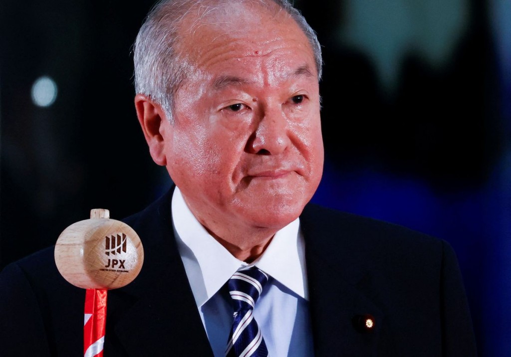 Japan's Finance Minister Shunichi Suzuki prepares to ring a bell during the New Year ceremony marking the open of trading in 2022 at the Tokyo Sto...