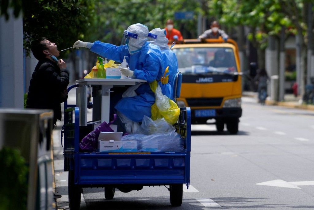 一名上海居民正在路邊接受新冠肺炎病毒檢測。(圖/路透社)
