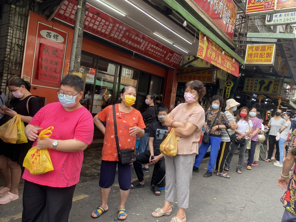 Residents line up to buy COVID rapid test kits in New Taipei City Friday. 
