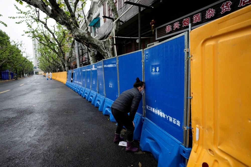 上海居民試圖向封鎖區外的小販購買食物（圖／路透）
