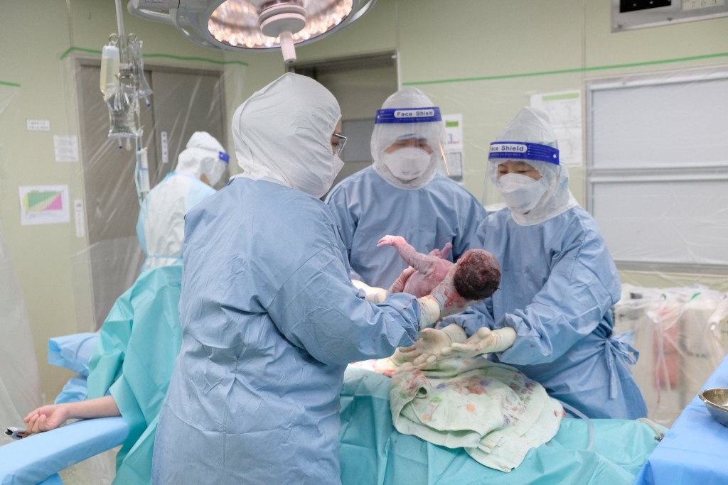 A team of over 10 doctors at the Pingtung Christian Hospital delivers a baby via C-section after the mother tested positive for COVID-19. (F...