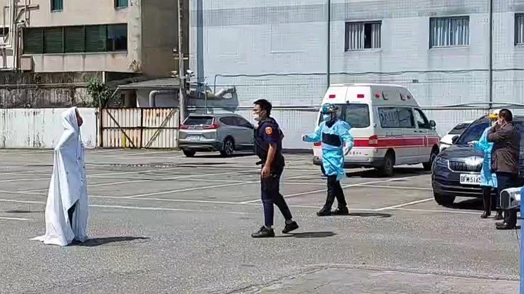 Indonesian man (left) stands wrapped in a sheet as police officer approaches. (Hualien County Police Department photo)
