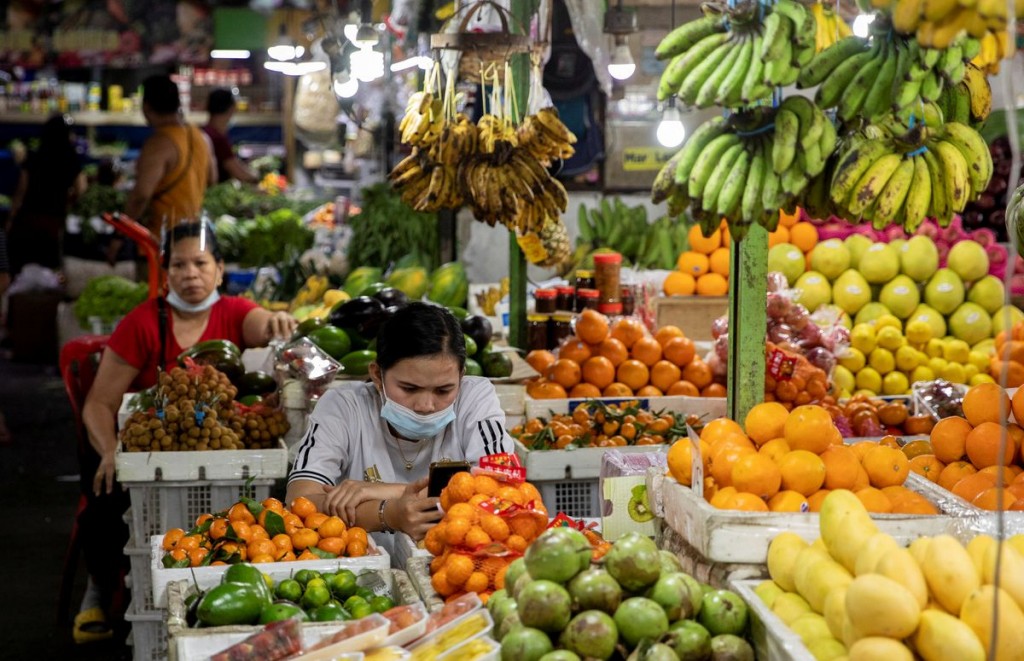 Vendors wearing face masks for protection against the coronavirus disease (COVID-19) stand by their fruit stalls at a public market in Quezon City, Me...