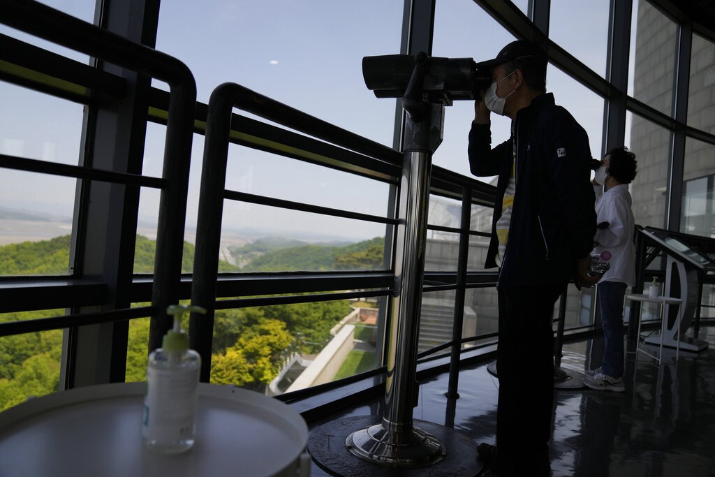 FILE - A bottle of hand sanitizer is placed as visitors use binoculars to see the North Korean side from the unification observatory in Paju, South Ko...