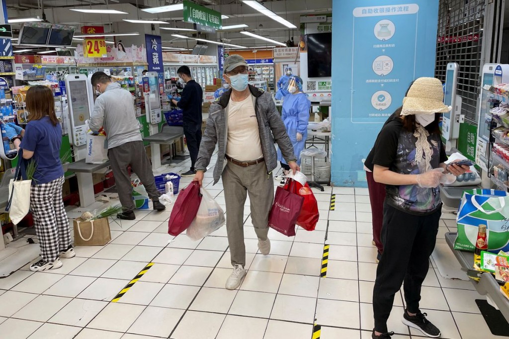 Customers wearing face masks use self-checkout counters at a reopened Carrefour supermarket amid the coronavirus disease (COVID-19) outbreak in Shangh...
