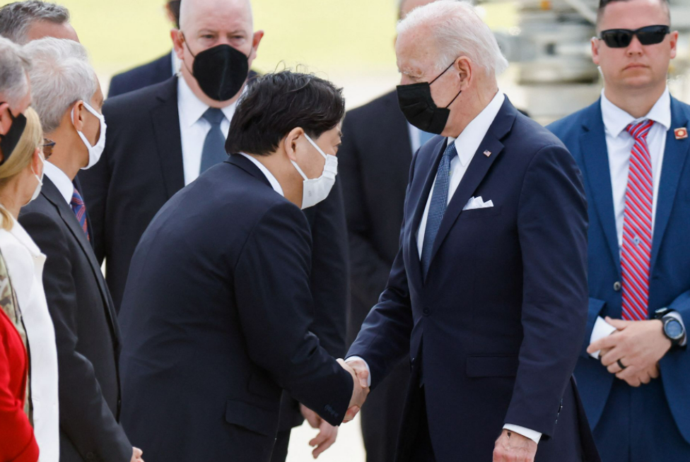 U.S. President Joe Biden shakes hands with Japanese Foreign Minister Yoshimasa Hayashi upon his arrival at Yokota U.S. Air Force Base in Fussa, on the...