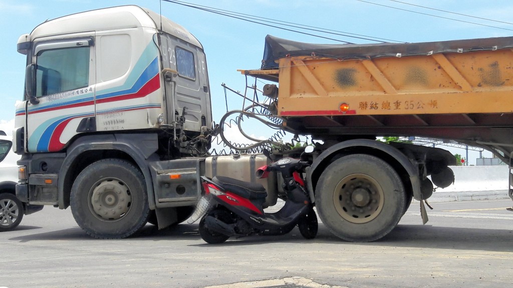 A scooter is caught in a large truck during a collision in Chiayi County. (Facebook, Chen Cheng photo)
