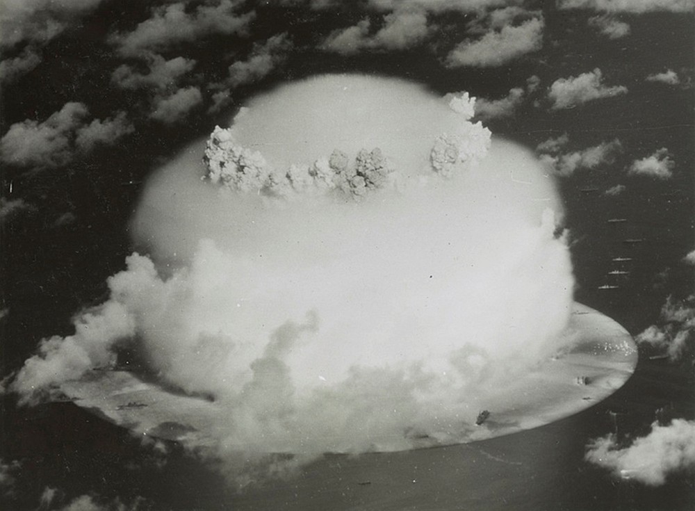 A mushroom cloud rises with ships below during Operation Crossroads nuclear weapons test&n...