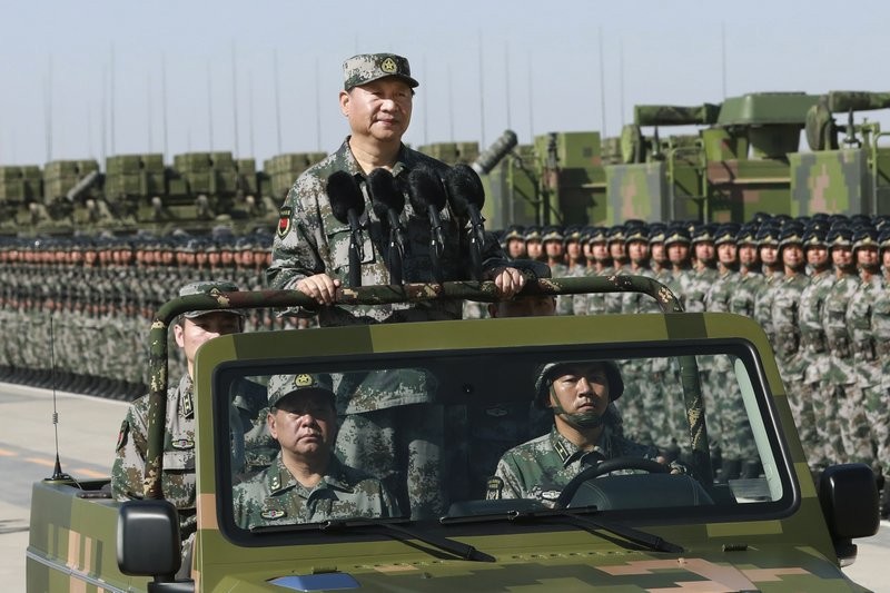 Chinese Chairman Xi Jinping stands in military jeep while inspecting PLA troops in 2017. 
