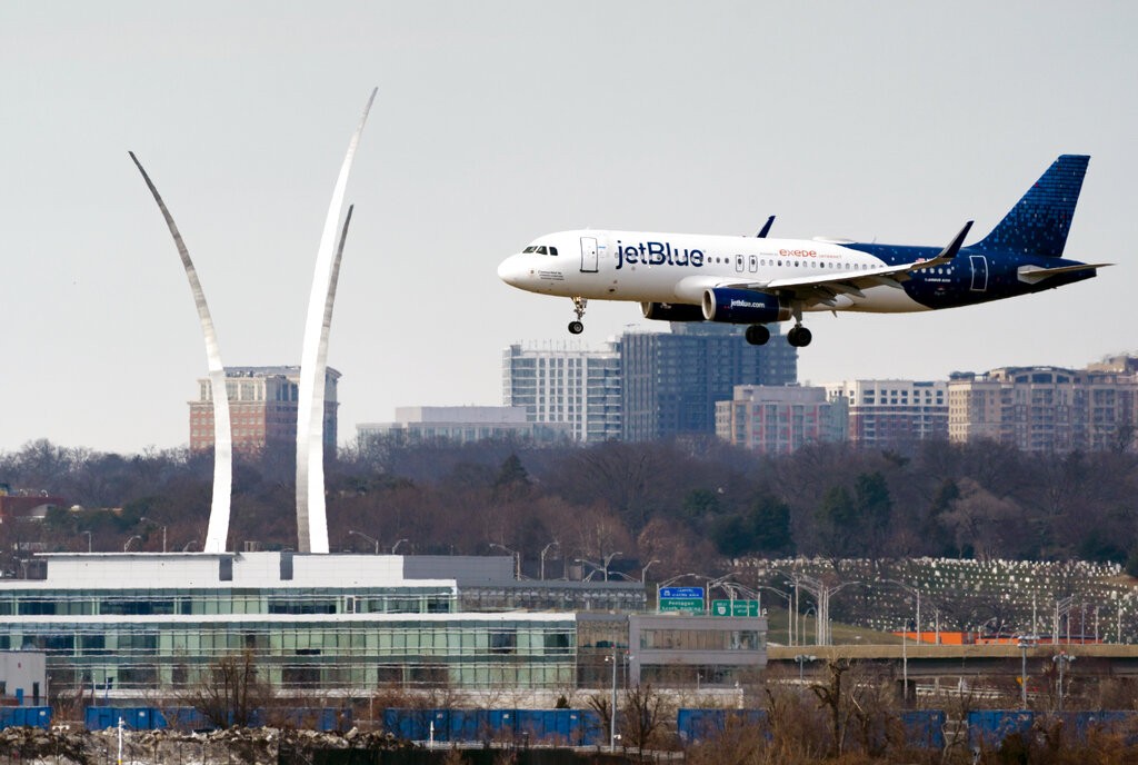 A JetBlue passenger flight lands at Reagan Washington National Airport in Arlington, Va., across the Potomac River from Washington, Wed., Jan. 19, 202...