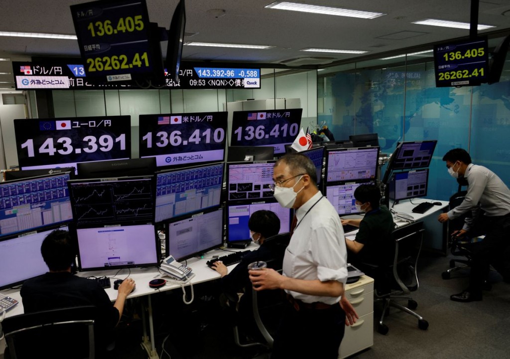 Employees of the foreign exchange trading company Gaitame.com work in front of monitors showing the Japanese yen exchange rate against the U.S. dollar...