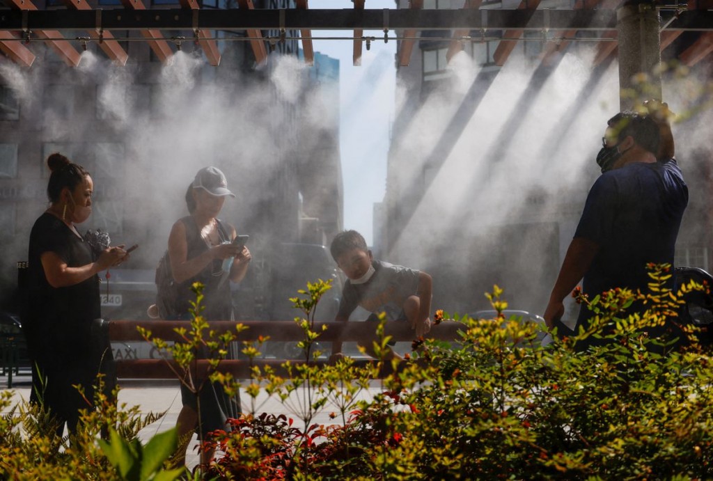 People take a break under a cooling mist as the Japanese government issues a warning over a possible power crunch due to a heatwave in Tokyo, Japan Ju...