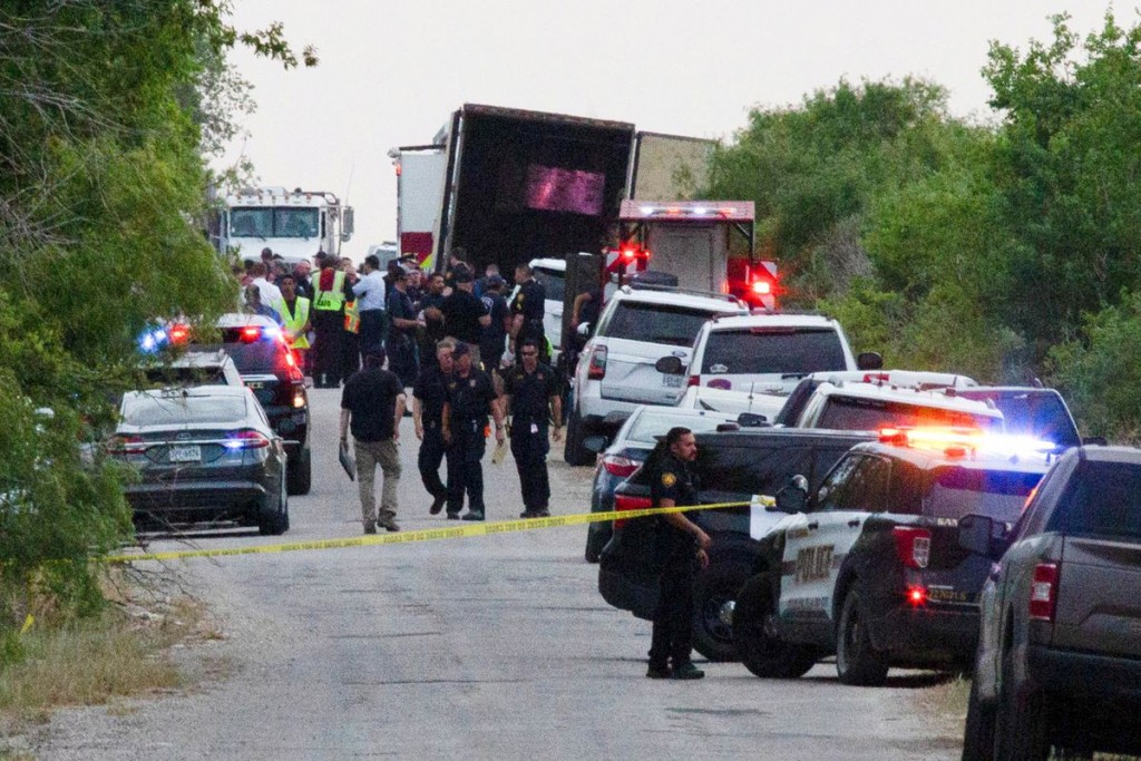 Law enforcement officers work at the scene where people were found dead inside a trailer truck in San Antonio, Texas, U.S. June 27, 2022. REUTERS/Kayl...