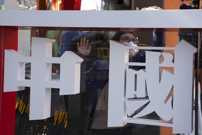 A worker cleans a panel with the words "China" written on it during a sporting goods brand promotion event in Beijing.
