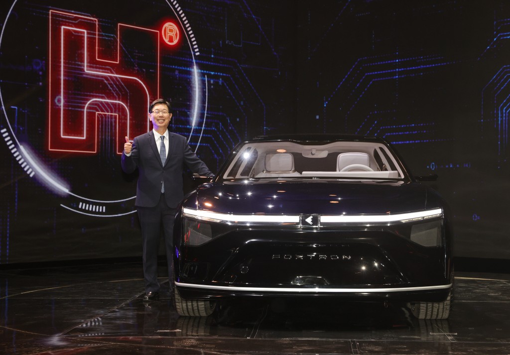 Foxconn Chairman Young Liu with the prototype for one of the company's EVs. 
