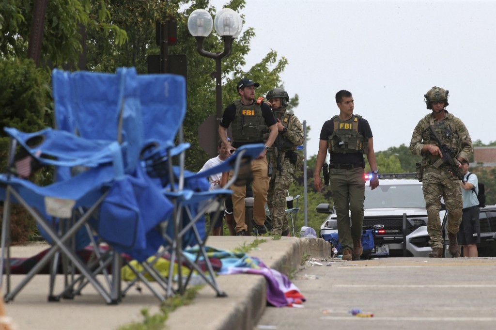 Law enforcement officers from multiple jurisdictions investigate the area in Highland Park, Illinois, on Monday, July 4, 2022, after a shooter fired o...