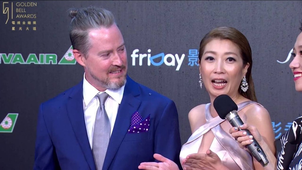 Christopher Downs (left) looks at Phoebe Huang as she answers media questions on red carpet at Golden Bell Awards in 2016. (YouTube, Golde Bell Awards...