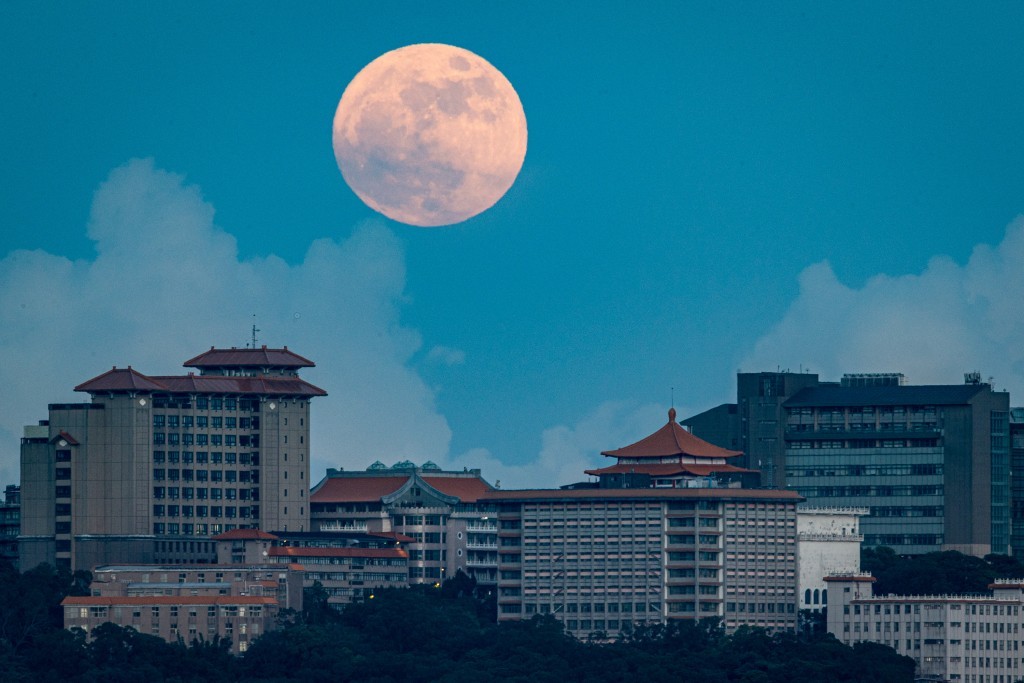 今年最大也是最 後一個超級月亮13日晚間登場。圖為超級月亮晚間7 時高掛在台北文化大學校區上方天際。
