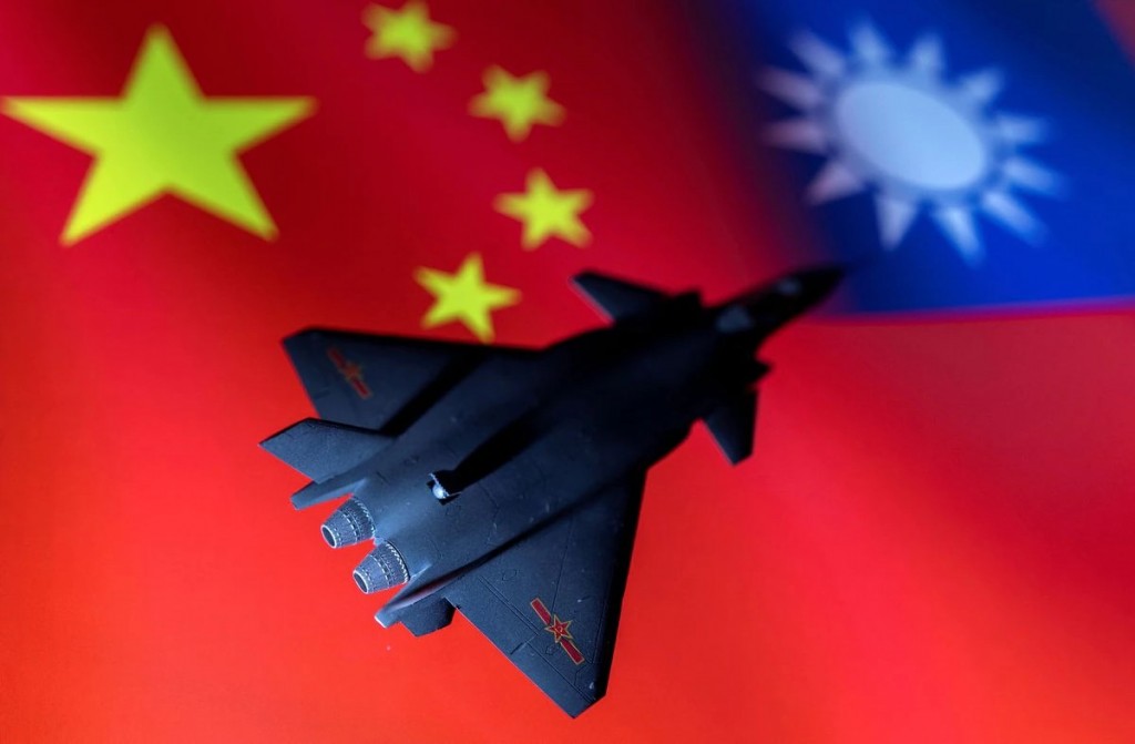 A model of the Chinese Fighter aircraft is seen in front of Chinese and Taiwanese flags in this illustration taken, April 28, 2022. Picture taken Apri...